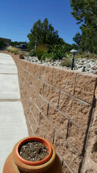 Block retaining wall and concrete walkway by Rising Sun Landscaping & Maintenance